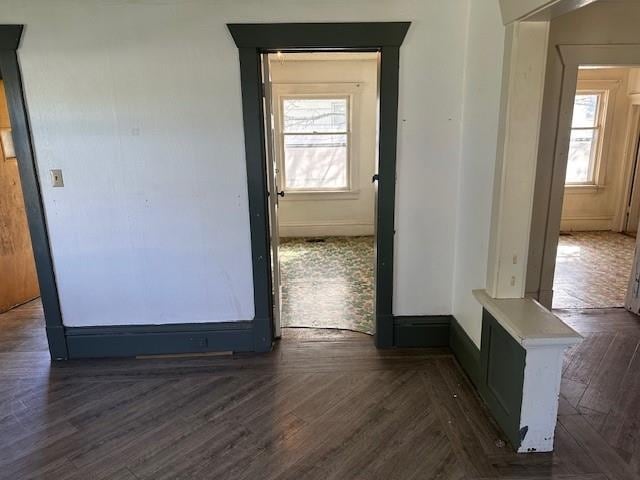 unfurnished room featuring parquet floors, baseboards, and a healthy amount of sunlight