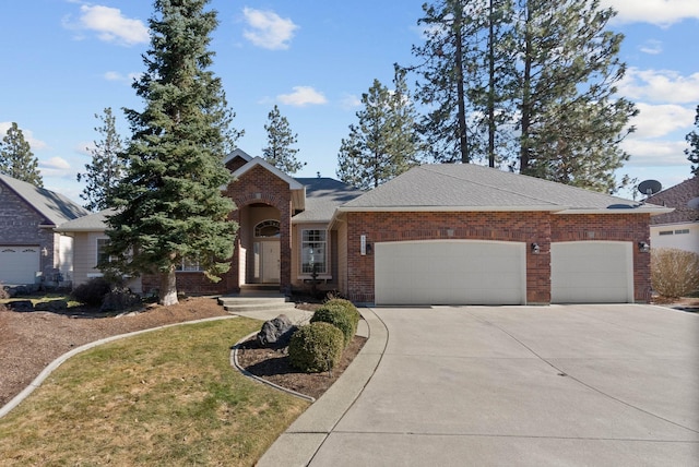 traditional home with roof with shingles, a front lawn, driveway, brick siding, and an attached garage