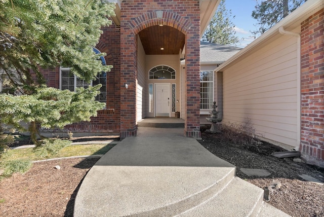 view of exterior entry featuring brick siding