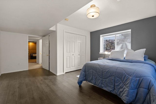 bedroom featuring baseboards, wood finished floors, and a closet