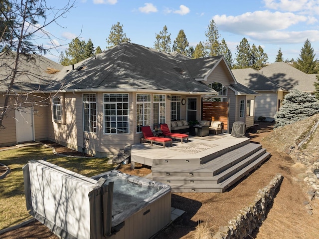 back of house featuring an outdoor living space, a wooden deck, roof with shingles, and a hot tub