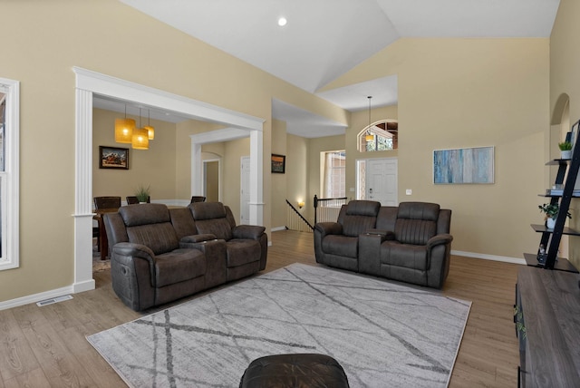 living area with baseboards, wood finished floors, and visible vents
