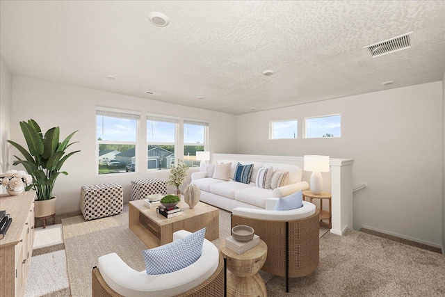 living room featuring baseboards, light carpet, visible vents, and a textured ceiling