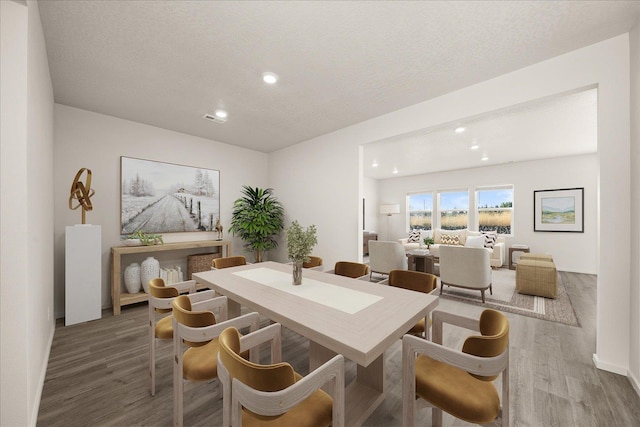 dining space featuring a textured ceiling, wood finished floors, baseboards, visible vents, and recessed lighting