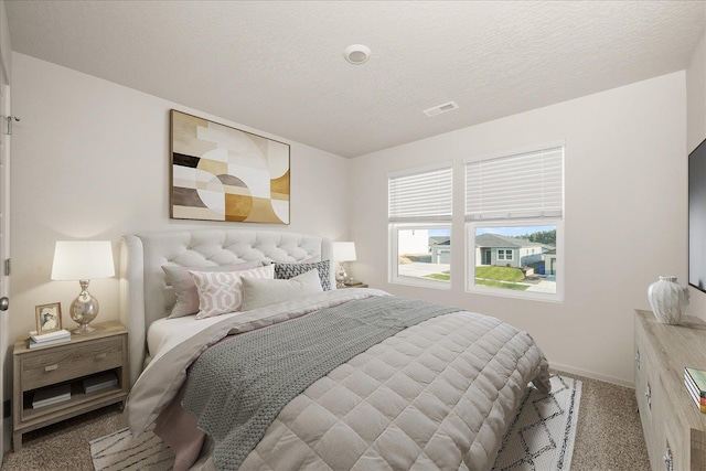 carpeted bedroom featuring a textured ceiling, visible vents, and baseboards