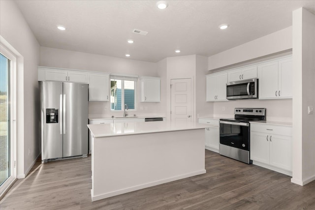 kitchen featuring light countertops, appliances with stainless steel finishes, a center island, and white cabinetry
