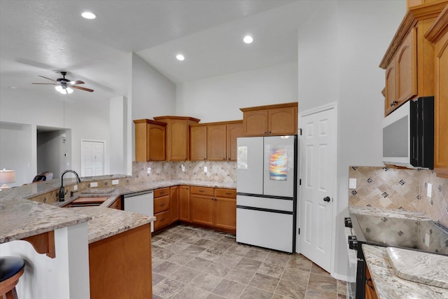 5818 S Abbott Rd, Spokane, WA 99224 - kitchen featuring white appliances, a sink, a ceiling fan, a peninsula, and light stone counters