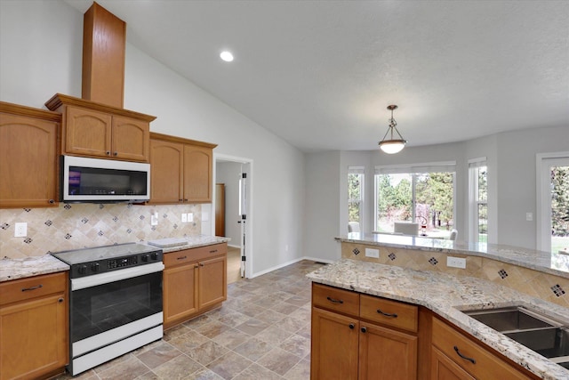 5818 S Abbott Rd, Spokane, WA 99224 - kitchen featuring white appliances, tasteful backsplash, healthy amount of natural light, baseboards, and lofted ceiling