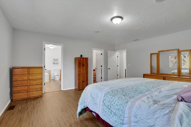 5818 S Abbott Rd, Spokane, WA 99224 - bedroom featuring light wood finished floors, baseboards, a textured ceiling, and ensuite bathroom