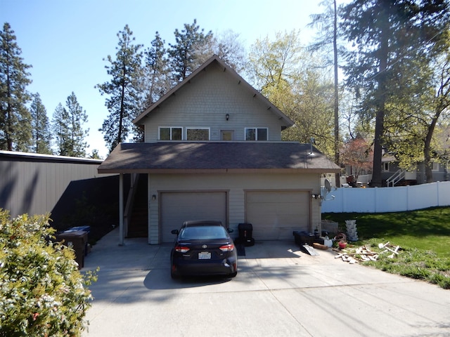 exterior space featuring a garage, driveway, and fence