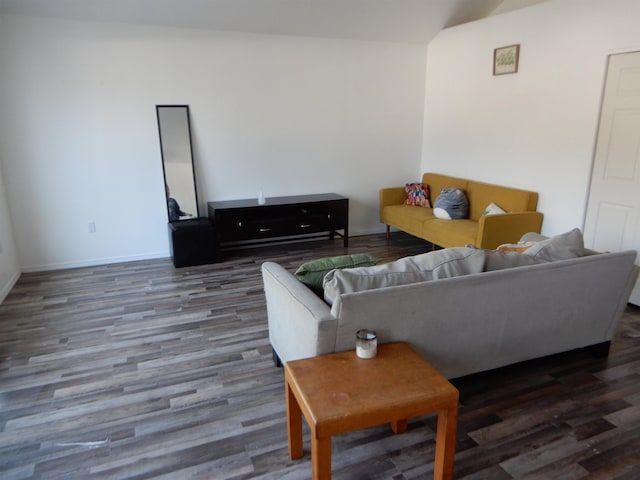 living area featuring vaulted ceiling, wood finished floors, and baseboards
