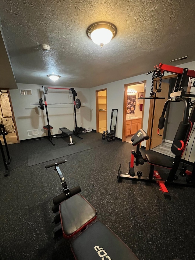 workout area with a textured ceiling and visible vents