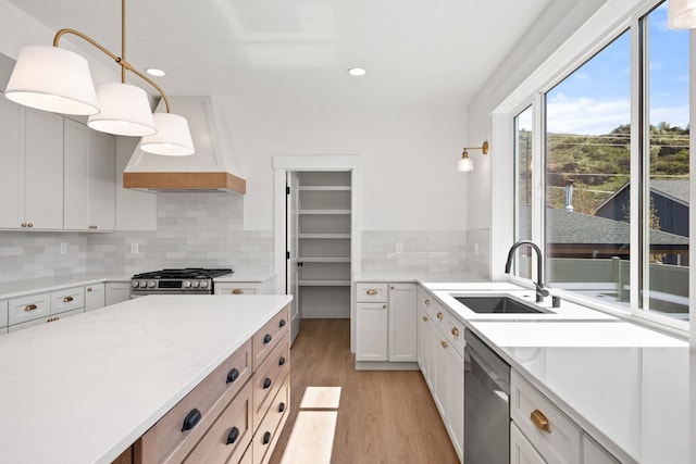 kitchen featuring recessed lighting, a sink, light wood-type flooring, appliances with stainless steel finishes, and custom range hood