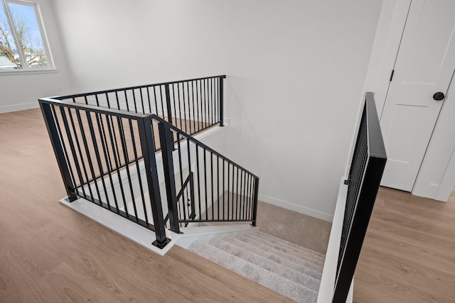 staircase featuring baseboards and wood finished floors
