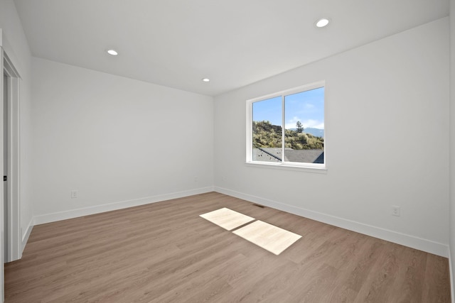unfurnished bedroom featuring recessed lighting, wood finished floors, and baseboards