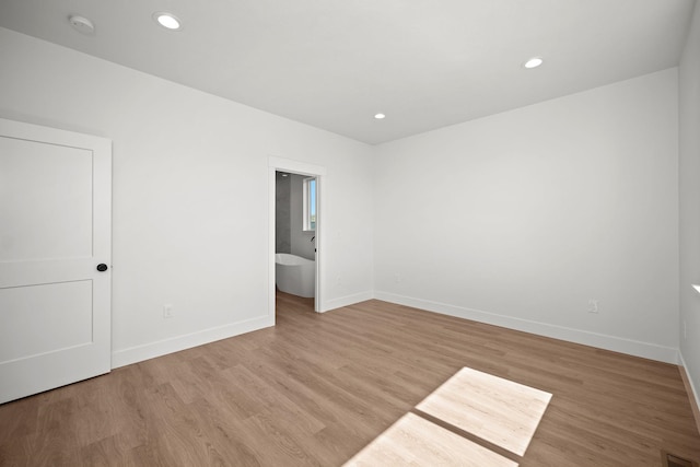 unfurnished room featuring baseboards, visible vents, light wood finished floors, and recessed lighting