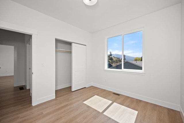 unfurnished bedroom with light wood-style flooring and baseboards