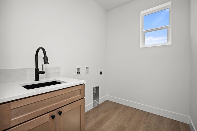 washroom featuring a sink, electric dryer hookup, cabinet space, baseboards, and washer hookup