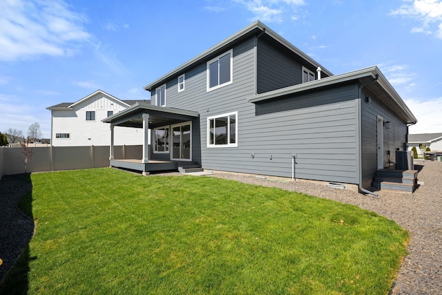 rear view of property with a lawn, a wooden deck, fence, and cooling unit