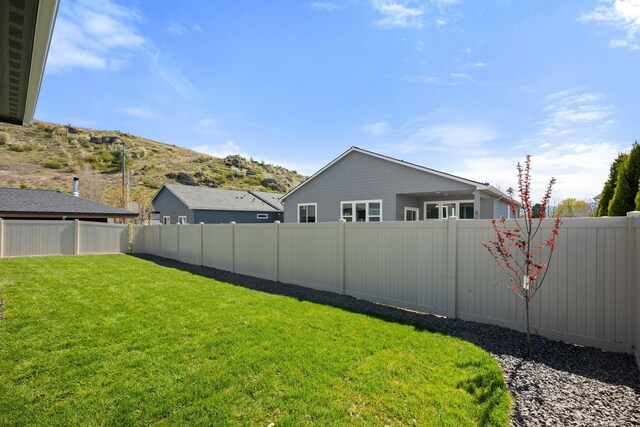 view of yard featuring a fenced backyard and a mountain view