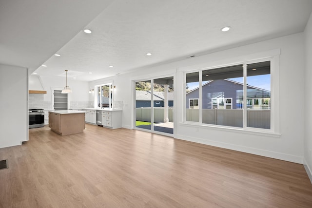 unfurnished living room featuring recessed lighting, light wood-style flooring, and baseboards