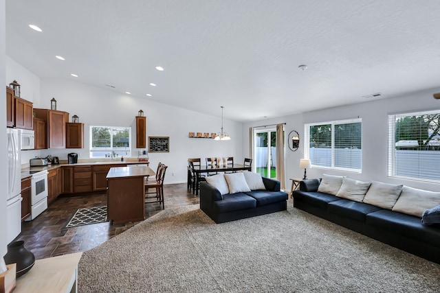 living room featuring baseboards, vaulted ceiling, visible vents, and recessed lighting