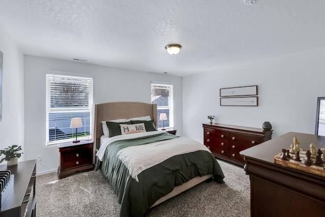 carpeted bedroom with visible vents and a textured ceiling