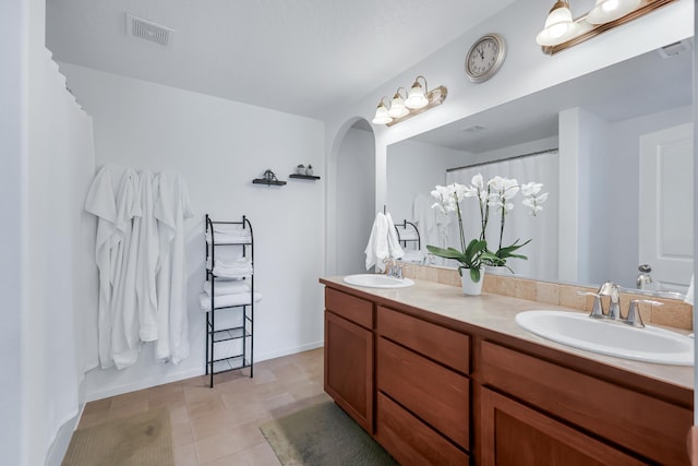 full bath featuring visible vents, a sink, and double vanity