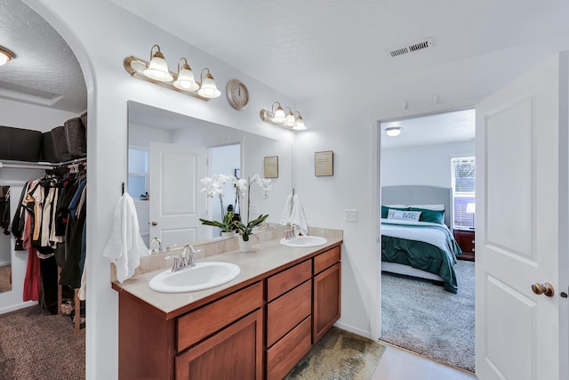 full bathroom featuring ensuite bathroom, visible vents, a sink, and double vanity