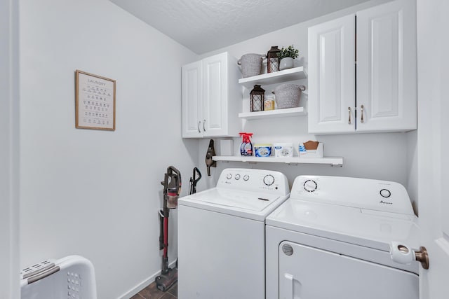 laundry room featuring dark wood-style floors, baseboards, separate washer and dryer, cabinet space, and a textured ceiling