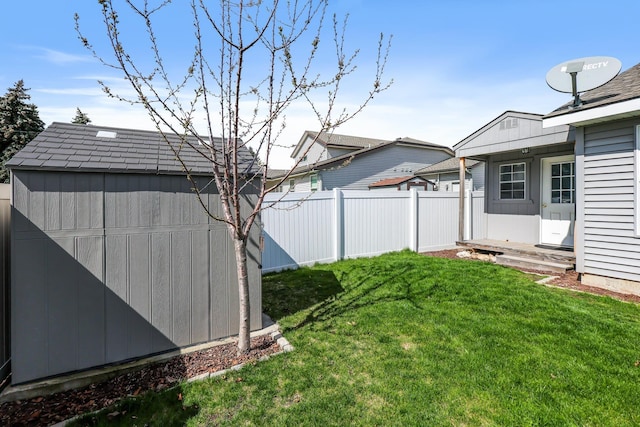 view of yard featuring an outdoor structure, fence, and a shed