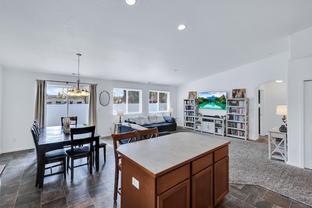 kitchen featuring open floor plan, stone finish flooring, a chandelier, and a kitchen island