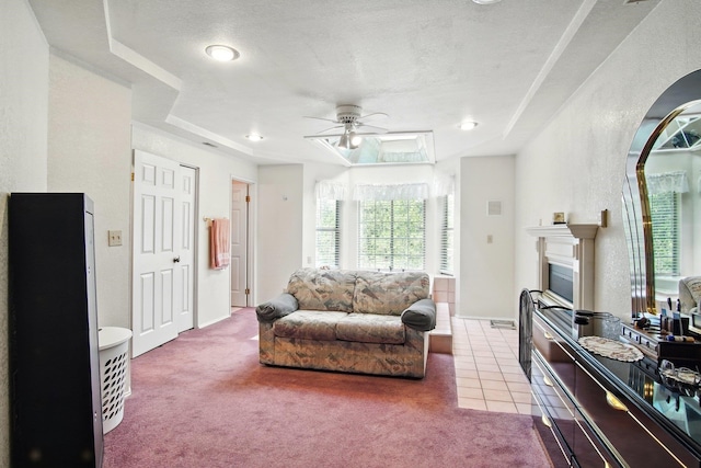 21203 W Beechwood Rd, Medical Lake, WA 99022 - carpeted living area featuring ceiling fan, a fireplace, a textured ceiling, baseboards, and tile patterned flooring