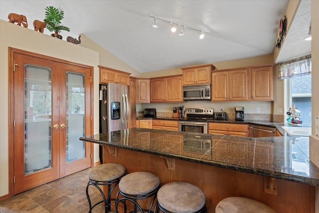 28 E Lindsey Ln, Spokane, WA 99208 - kitchen featuring appliances with stainless steel finishes, lofted ceiling, french doors, track lighting, and a peninsula