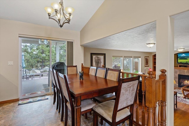 28 E Lindsey Ln, Spokane, WA 99208 - dining area featuring a chandelier, lofted ceiling, baseboards, a fireplace, and a textured ceiling