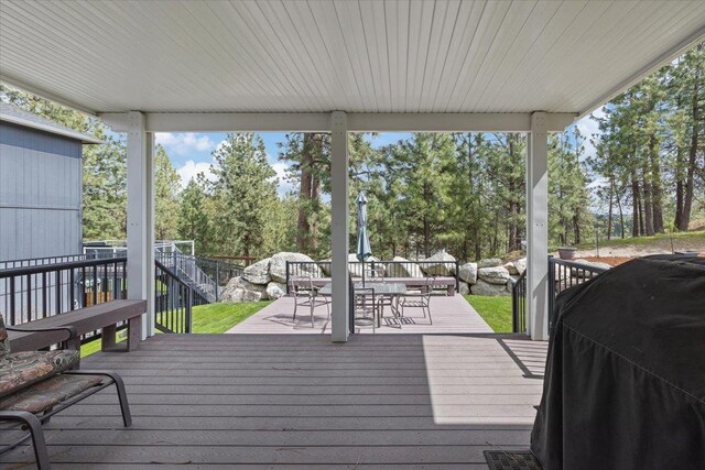 28 E Lindsey Ln, Spokane, WA 99208 - wooden terrace featuring a grill, outdoor dining space, and view of wooded area