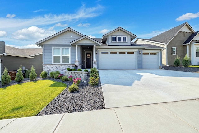 craftsman inspired home featuring concrete driveway, an attached garage, stone siding, and a front lawn