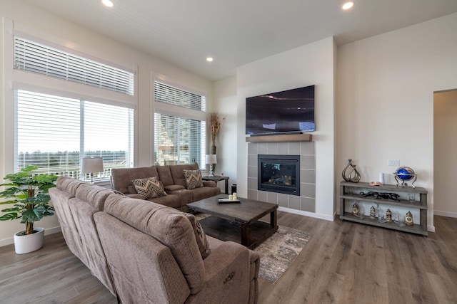 living area featuring a fireplace, wood finished floors, baseboards, and recessed lighting