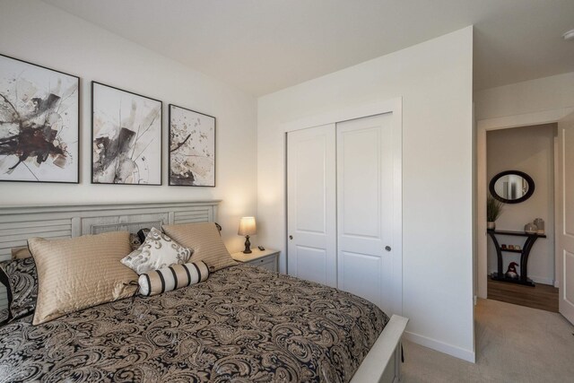 carpeted bedroom with baseboards and a closet