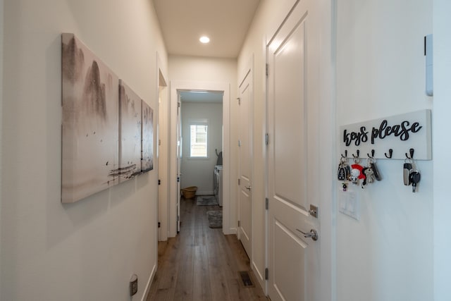 hall featuring washer / dryer, wood finished floors, visible vents, and recessed lighting