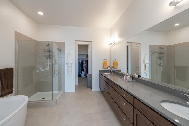 bathroom with a shower stall, a freestanding tub, a sink, and double vanity
