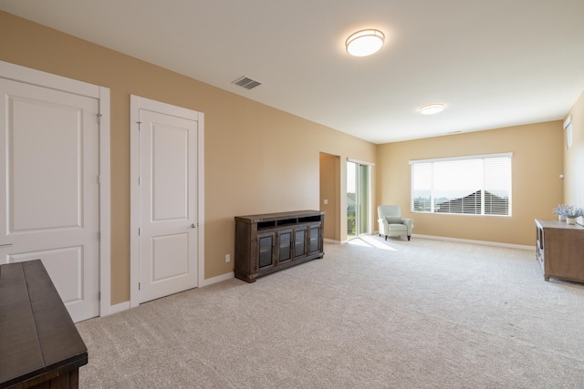 unfurnished room with carpet, visible vents, and baseboards