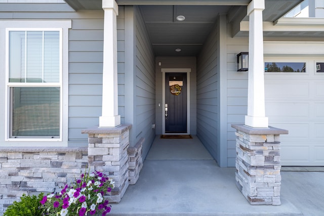 property entrance featuring covered porch and a garage