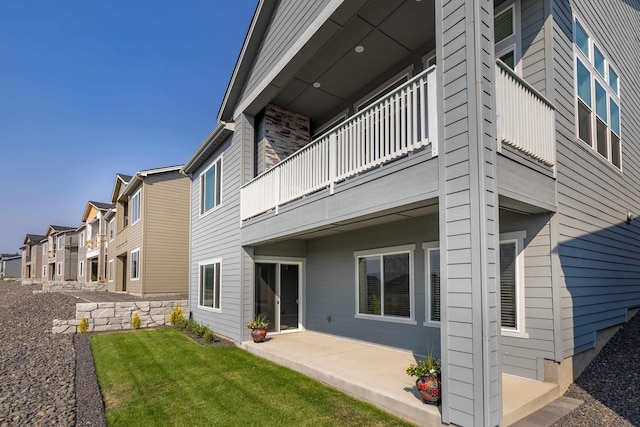 exterior space with a yard, a residential view, a patio, and a balcony