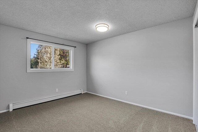 carpeted spare room featuring a baseboard radiator, baseboards, and a textured ceiling