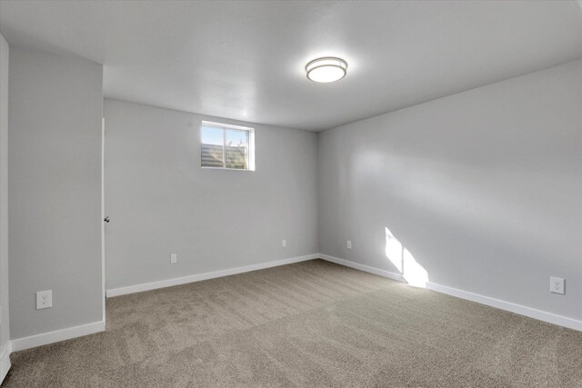 carpeted empty room with baseboards