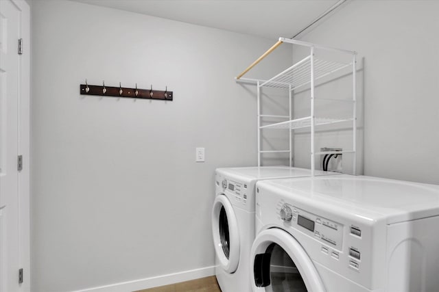 laundry area with washing machine and dryer, baseboards, and laundry area