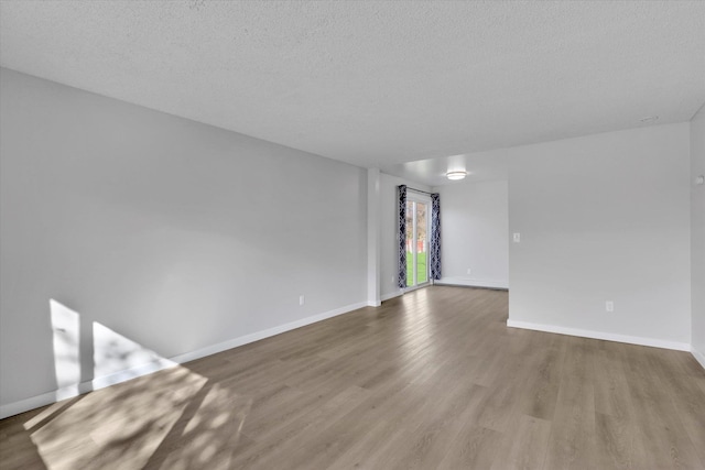 interior space featuring baseboards, wood finished floors, and a textured ceiling