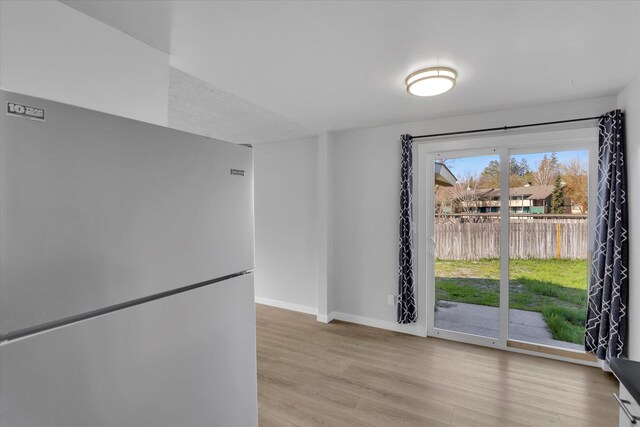 spare room with light wood-style floors and baseboards