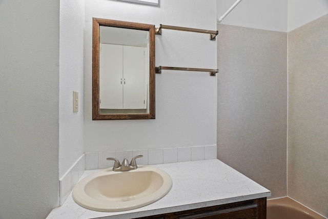 full bath featuring vanity and a tub